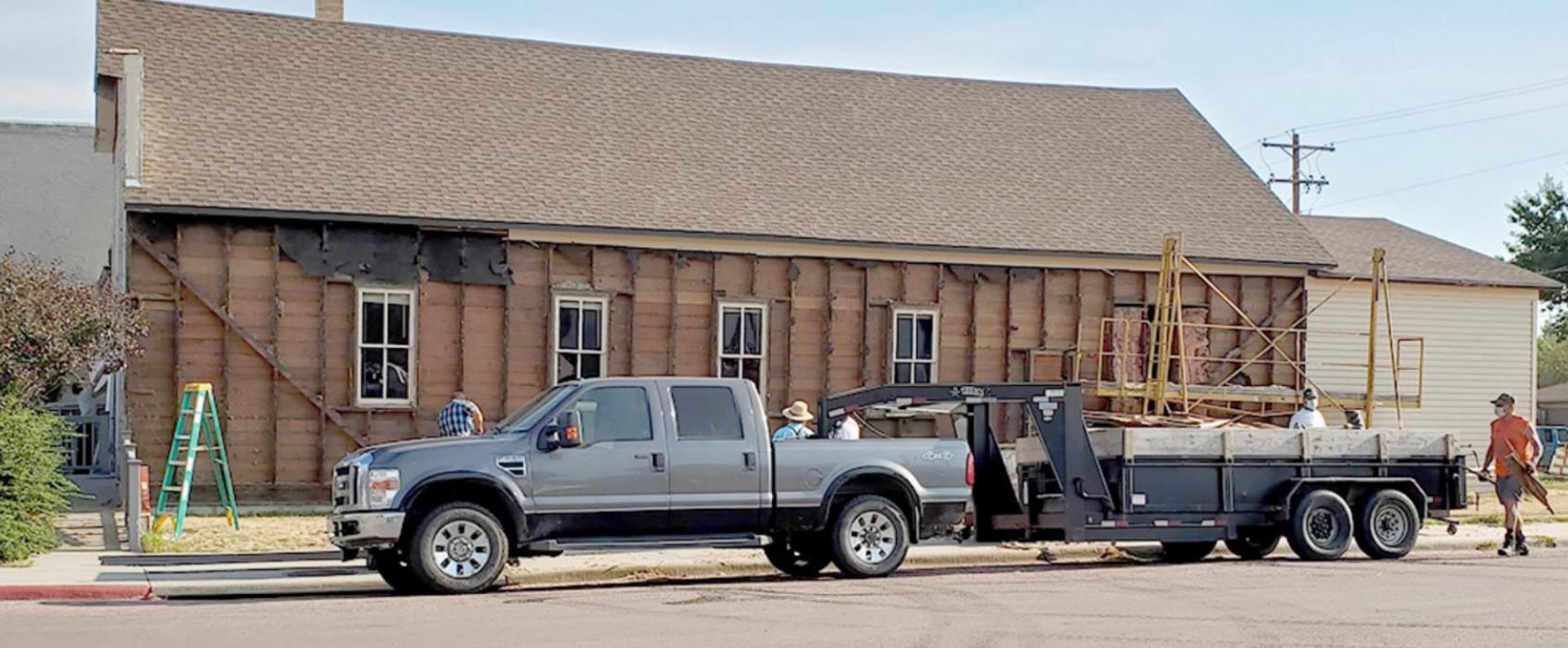 By Tuesday morning, the old siding had been removed from the south side of Dixon Townhall, in preparation for insulation and new siding.