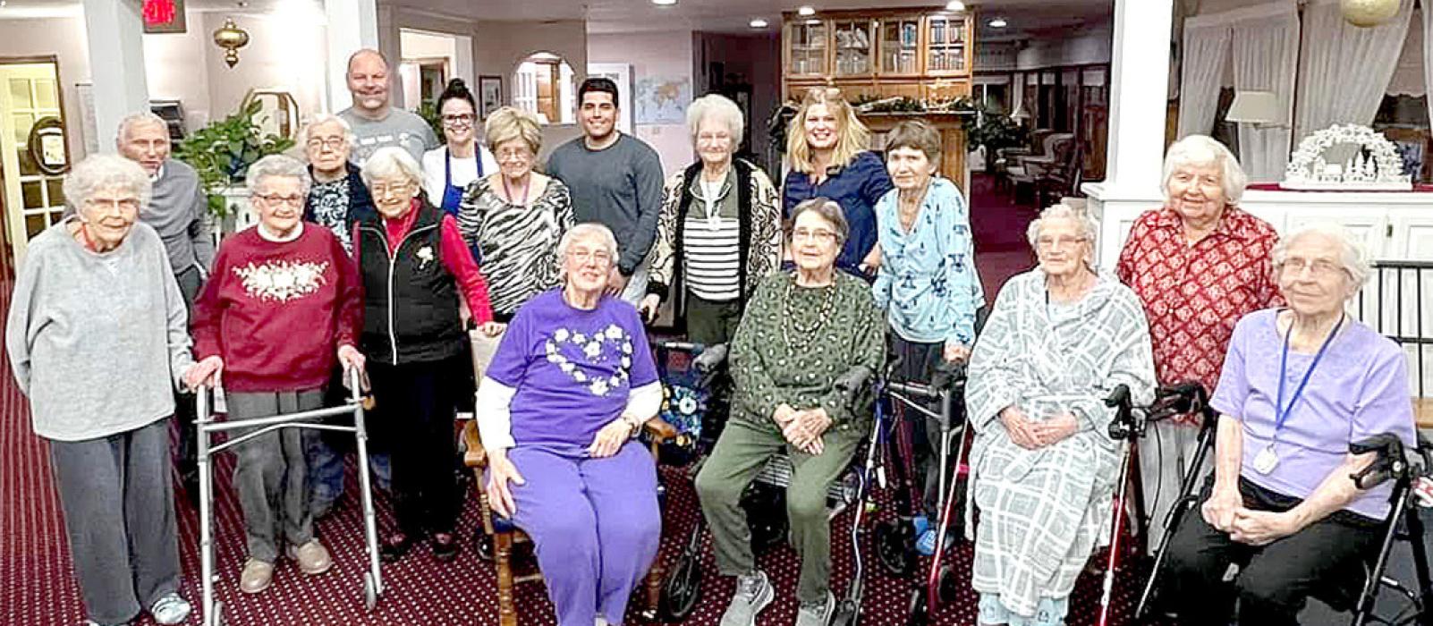 Sgt. Allen Sanchez (back row, under the flag) is shown here with the new friends he made at Silver Threads when he became stranded by the storm.