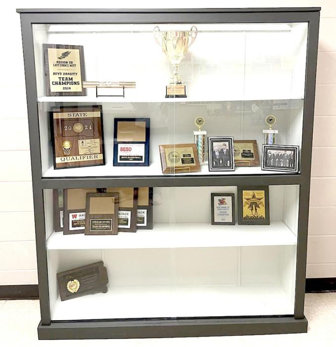 The trophy case is a legacy piece salvaged from the old school. It was refurbished by the class of 2026, and is destined to live a second life in the new school where it is already filling up with awards and trophies.