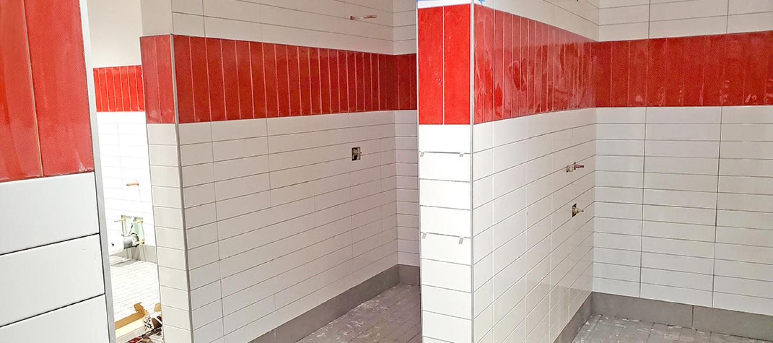 The locker rooms at the new wellness center will have private shower stalls tiled in the school colors.