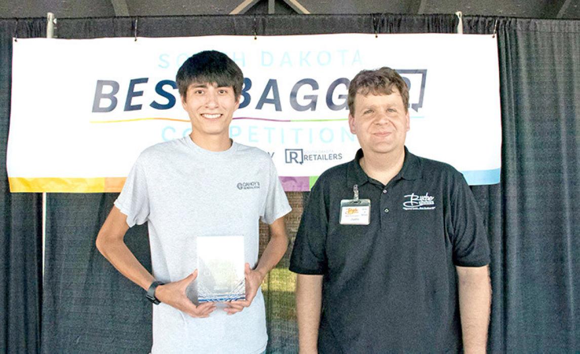 Mahlon Bruguier, l, representing Cahoy’s General Store in Lake Andes, was the top grocery bagger at the South Dakota Best Bagger competition at the South Dakota State Fair. Justin Ekroth, r, of Buche Foods in Gregory placed second. (photo from South Dakota Retailers Association)