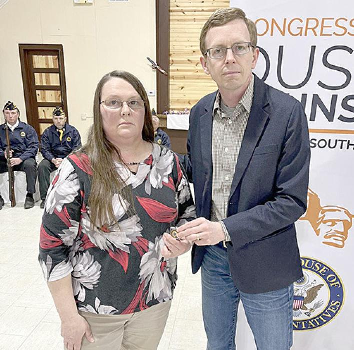Jeanne Davis, left, accepted medals in honor of John Davis and Ray Sip, from Rep. Dusty Johnson, right.