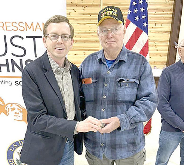 Rep. Dusty Johnson, left presented Frank Heagney, right, with a medal for his service.