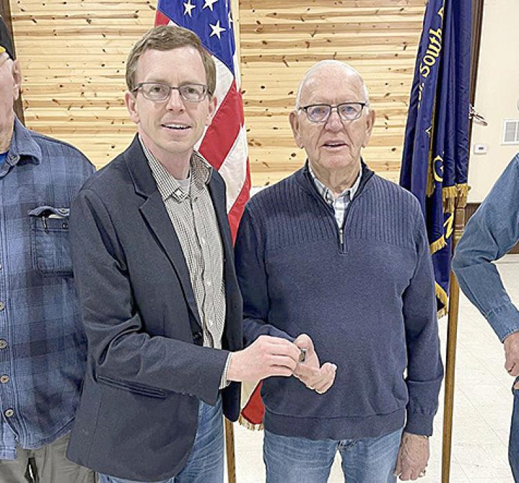 Rep. Dusty Johnson, left presented John Applebee, right, with a medal for his service.