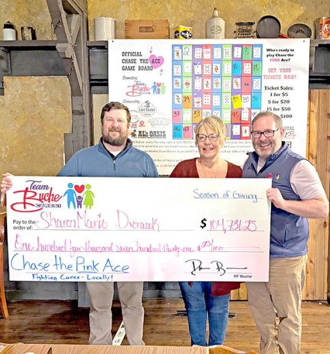 Sharon Marie Dvoracek (middle), formerly of Wagner, receives her winnings from RF Buche (right).