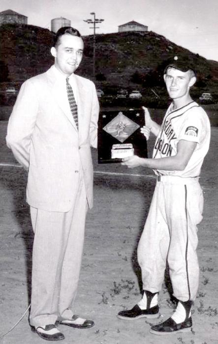 Wayne McCollum, team captain of the 1954 Jr. Legion State B championship baseball team, is being presented with the runner-up plaque from the overall state tournament series.