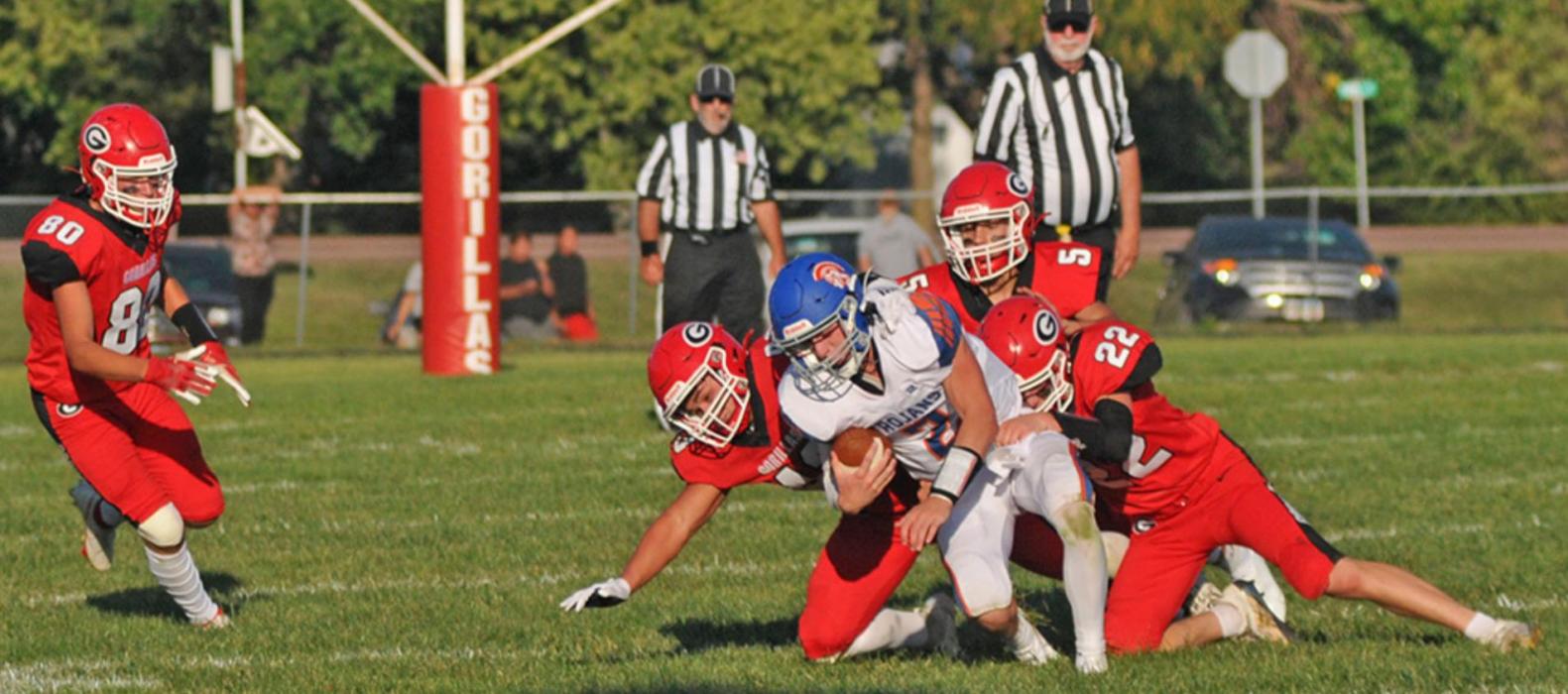 Three Gorilla defenders stop a Parkston ball carrier.