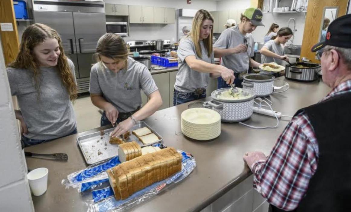 Gregory County FFA chapter members from left; Kaydence Klein, Kate Weborg, Hailey Haiar, Justin Vomacka, and Avery Zeisler make meals for people attending their FFA Meal on Main fundraiser for the chapter and to kick off National FFA Week at the Burke Civic Center. (Photo by Matt Gade/Mitchell Republic)