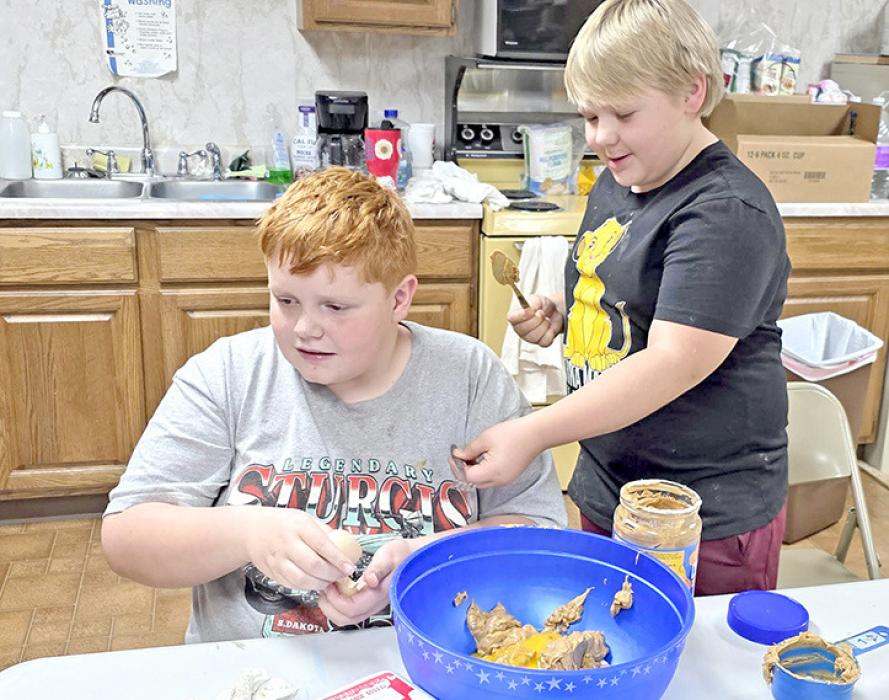 Joey and Bentley mix up the ingredients for peanut butter cookies.