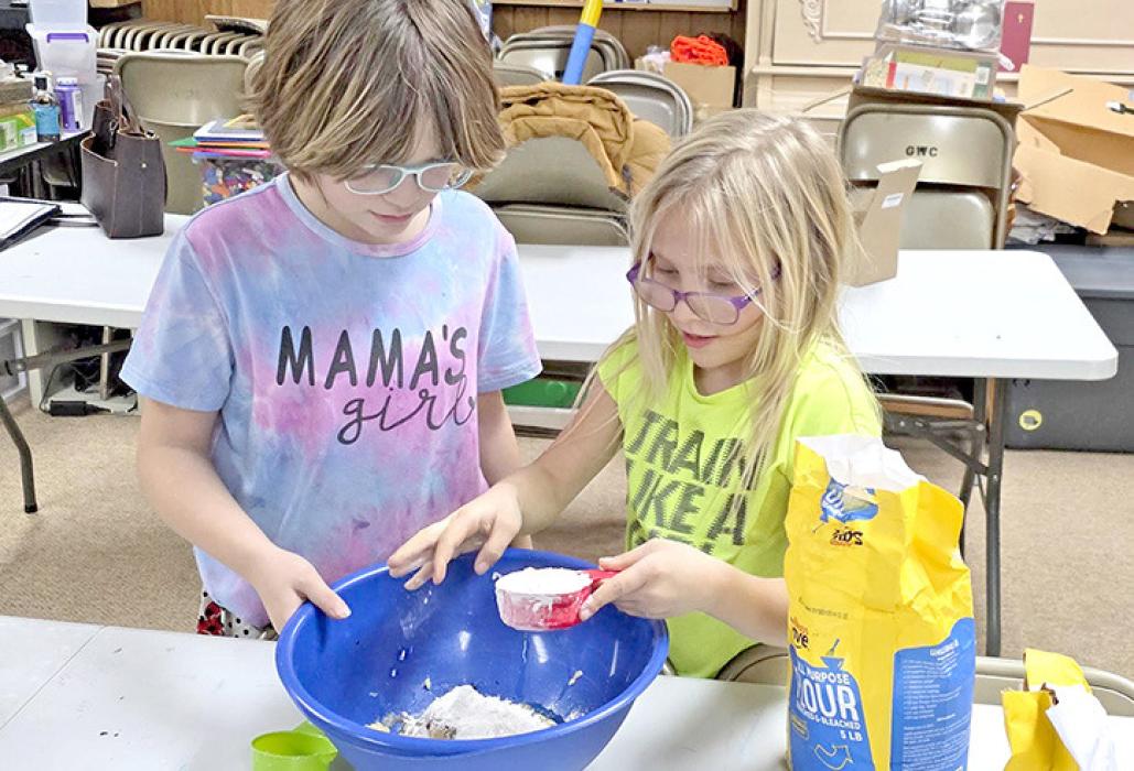 Maya and Brooke carefully measured the ingredients for banana bread.