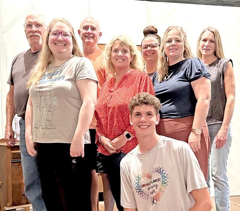 Cast members include back row, l to r: Wes Schell, Dr. Joe Hull, Tayler Spraw, and Ann Fogel. Middle row, l to r: Caitlin Kurtz, Jana Winters, and Ronda Graber. Front row: George Timanus.