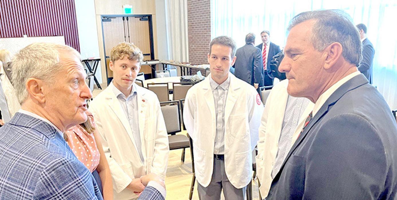 Gov. Larry Rhoden, left, and South Dakota Board of Regents President Tim Rave speak in downtown Sioux Falls on Aug. 14, 2025, before the University of South Dakota’s announcement that the state’s only medical school will move to Sioux Falls. (Photo by Makenzie Huber/South Dakota Searchlight)