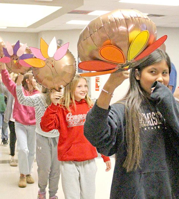 Unlike the big parades, the balloons in this parade were more manageable and posed no danger to buildings or people due to gusty winds. Each elementary class carried themed balloons they decorated during their STEM activities in the library. The fifth graders and their Tom-the -Turkeys followed the drum corps to lead the festive balloon parade.