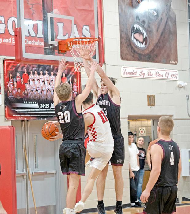 Cruz Klundt well guarded by two Platte-Geddes Black Panthers as he attempts an additional two points for the Gorillas. (Photo by Melissa Bearshield)