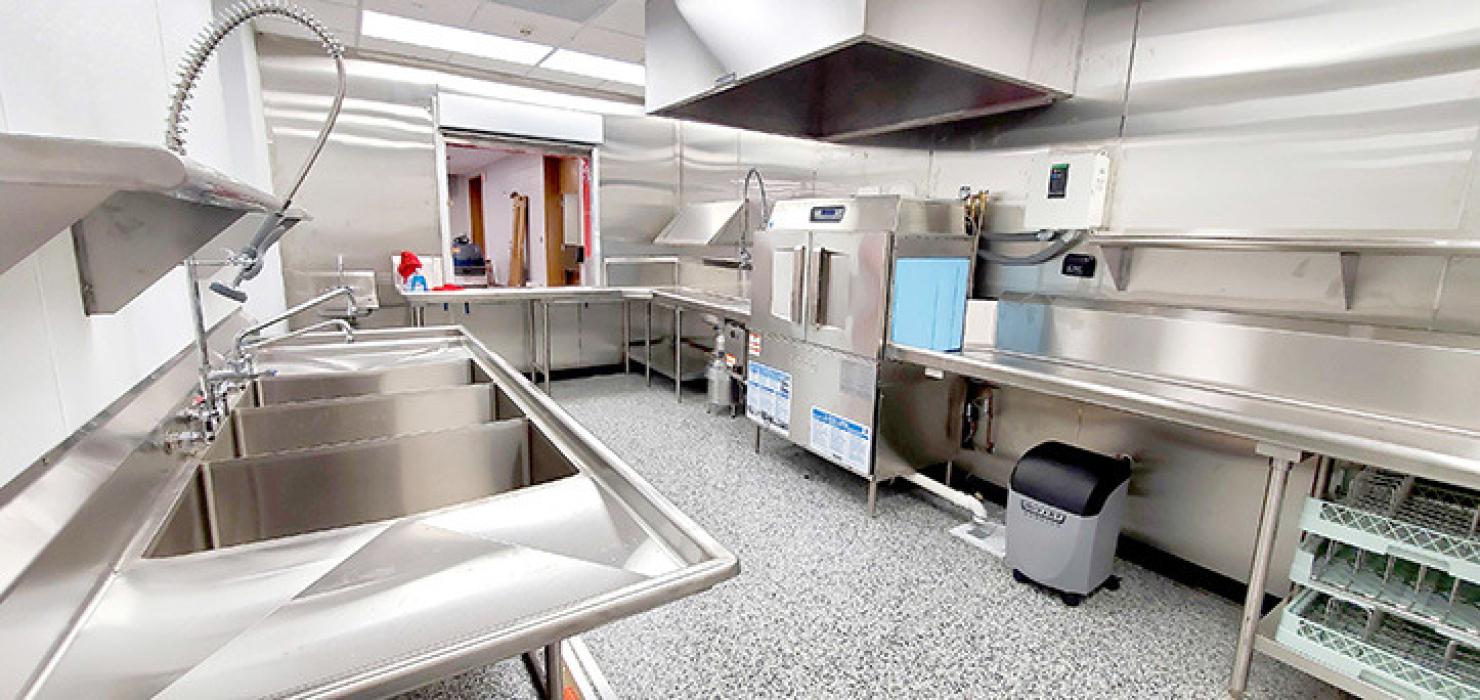 The cleaning side of the kitchen is outfitted with a new dishwasher, garbage disposal, and sinks large enough to completely submerge sheet pans.