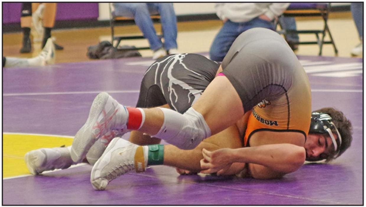 Jhett Eklund, shown here pinning Day Heminger of Mobridge-Pollock, finished fourth at the tournament. (Photo courtesy of Burke Gazette)