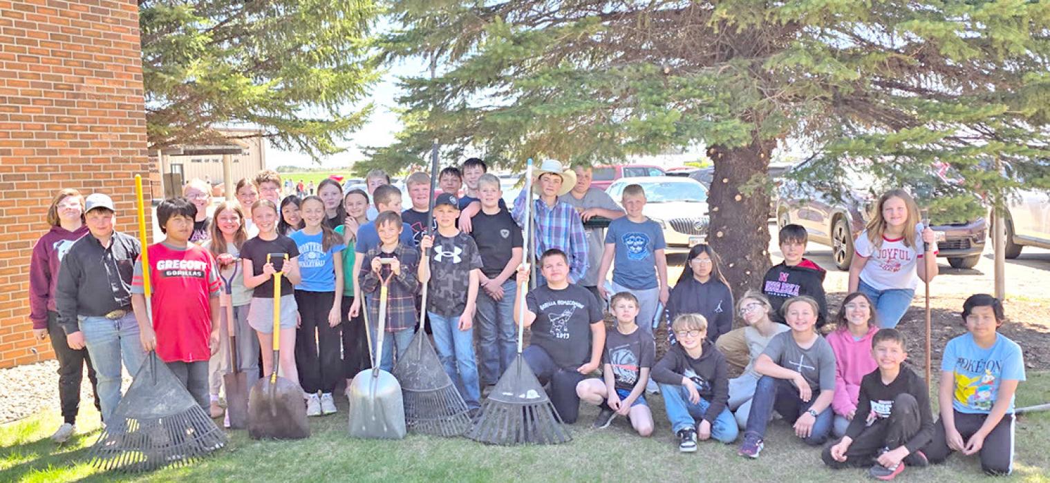 3rd and 5th grade helped trim and clean up around the memorial trees at the school.