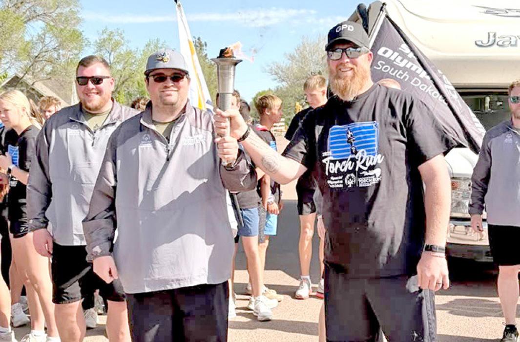 Members of the Gregory Police Department — Tom Claussen, top, and Jeremy Atkins, bottom — helped carry the torch, joining local athletes and others from across the state in running down Logan Avenue from the school to the hospital.