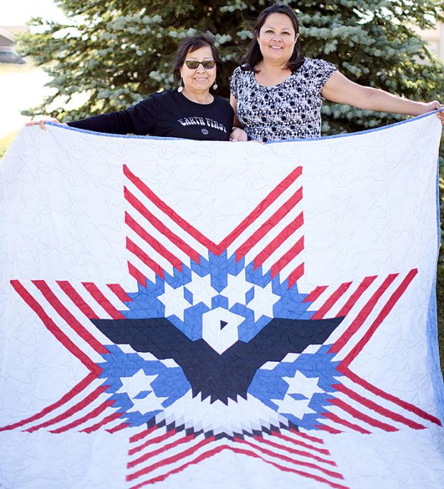 Wilma Robertson and daughter Lisa White Pipe display a quilt that was featured in Quiltfolk magazine.