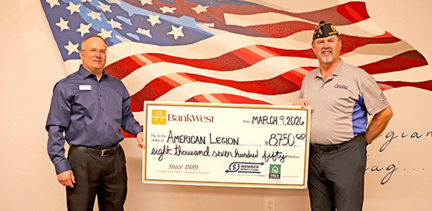 BankWest’s Branch Manager David Kotrba presents a check to American Legion District Commander Greg Smith.