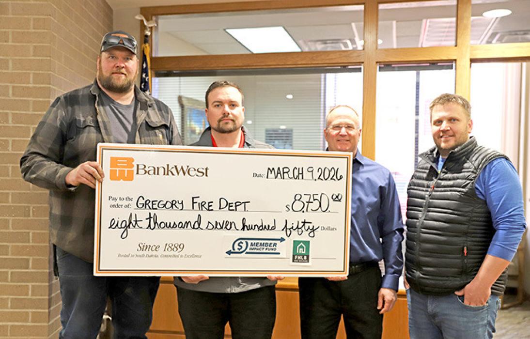 BankWest’s Branch Manager David Kotrba and Business Development Officer Alex Hamilton present a check to Gregory’s Volunteer Fire Chief Joel Bartling and Treasurer Travis Harford.