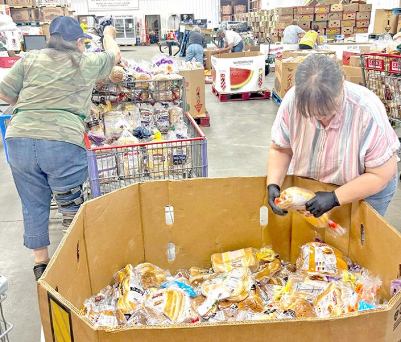 Volunteers at the Faith Temple Church food giveaway in Sioux Falls, SD, fill boxes with food and prepare to load them into cars on June 27, 2025.