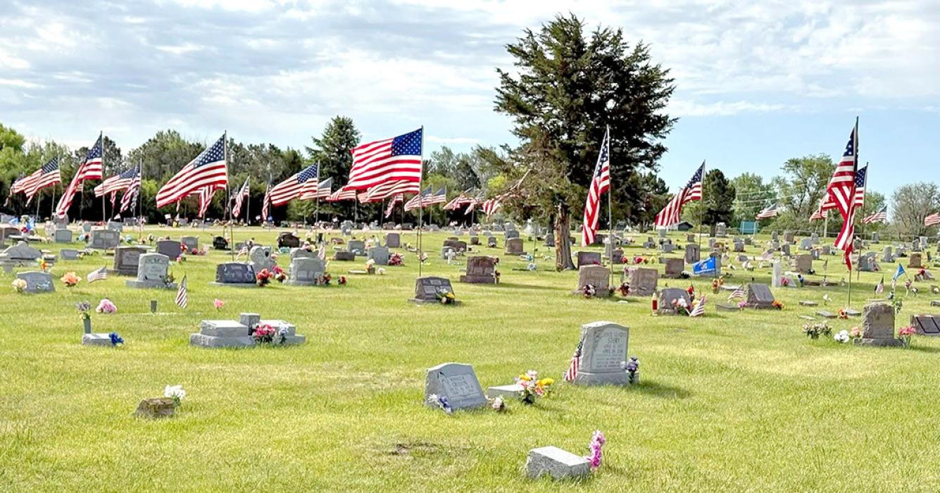American flags line the paths at Herrick Cemetery (l), and the Colome Cemetery (r).