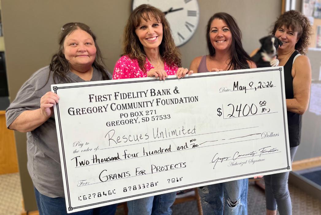 Pictured from left to right are Marie Palmer from Rescues Unlimited, Rhonda Vaughn-Waterbury and Aliza Wonnenberg, First Fidelity Bank &amp; Gregory Community Foundation board members, and Raquel Opbroek, also from Rescues Unlimited, holding Badger.