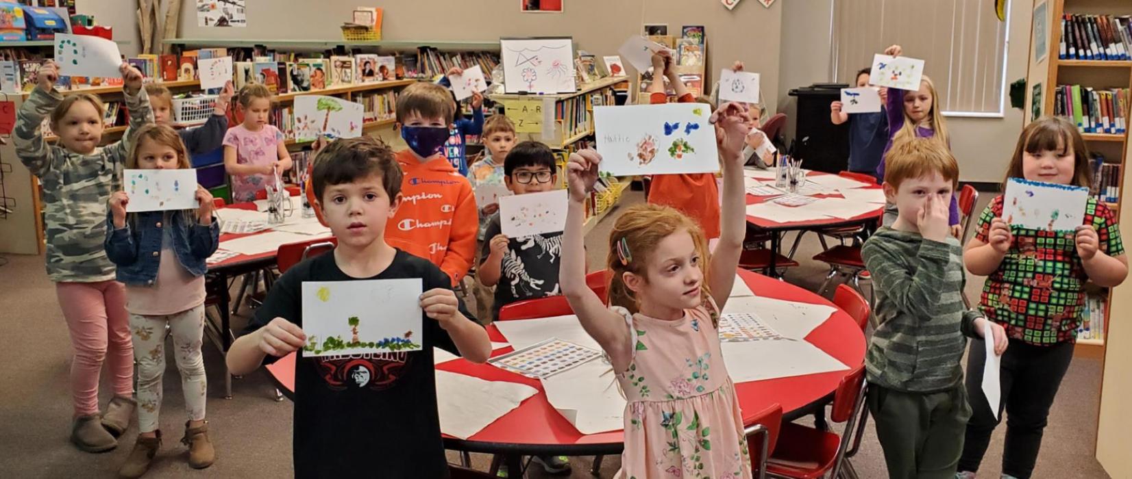 The kindergarten class proudly displays their fingerprint art.