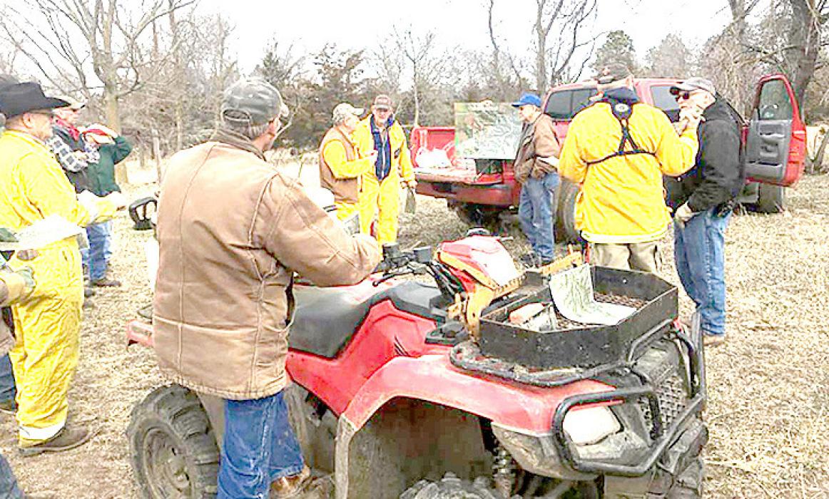 Tom Hausmann gives a briefing before the burn, while Greg Schmitz listens with the rest of the burn crew.