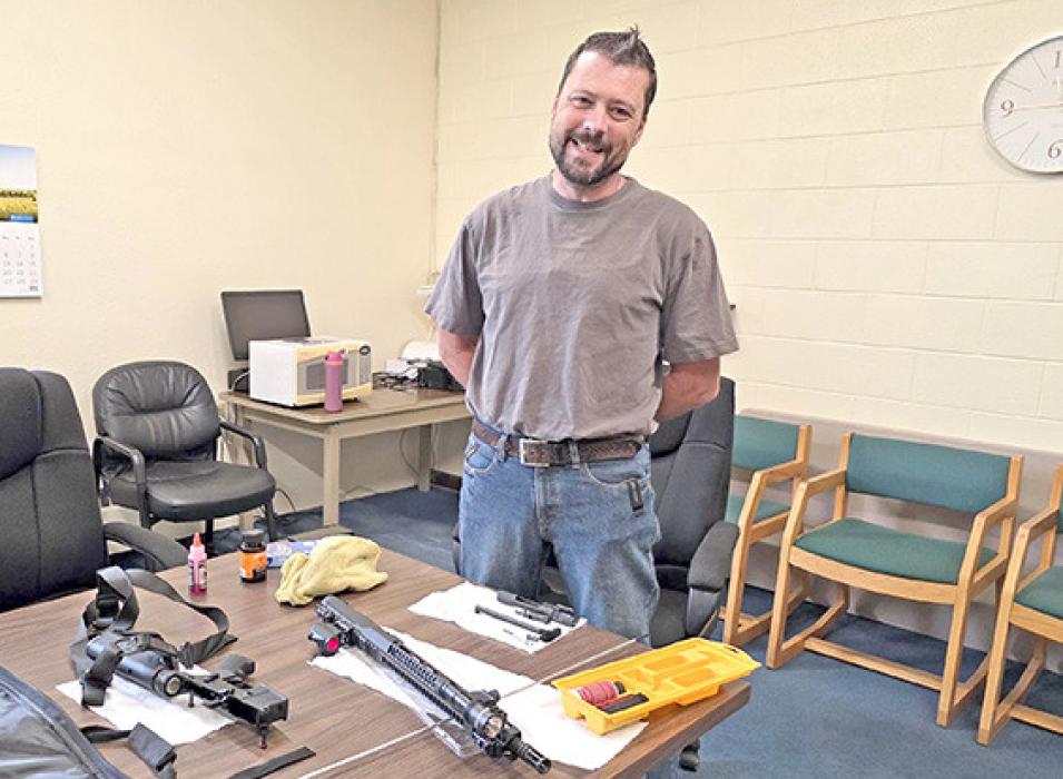 Justin Jelinek takes a break from cleaning his gun to discuss his hiring as the new police office for Gregory.