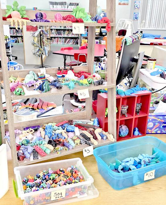 The school library has acquired four 3-D printers, which Librarian Holly Whitney uses, in part, to produce items for sale that help fund the STEAM programs she teaches. She also makes items for students to redeem their banana bucks for.